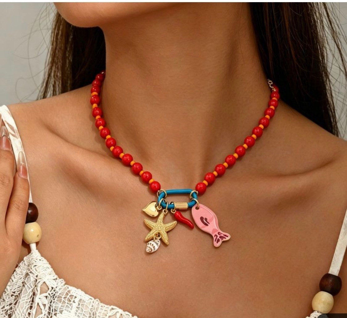 Red beaded charm necklace worn with a white top