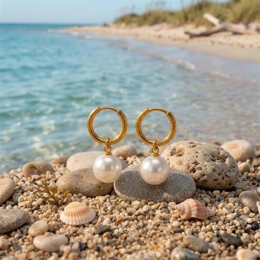 Small baroque pearl drop hoop earrings on beach pebbles