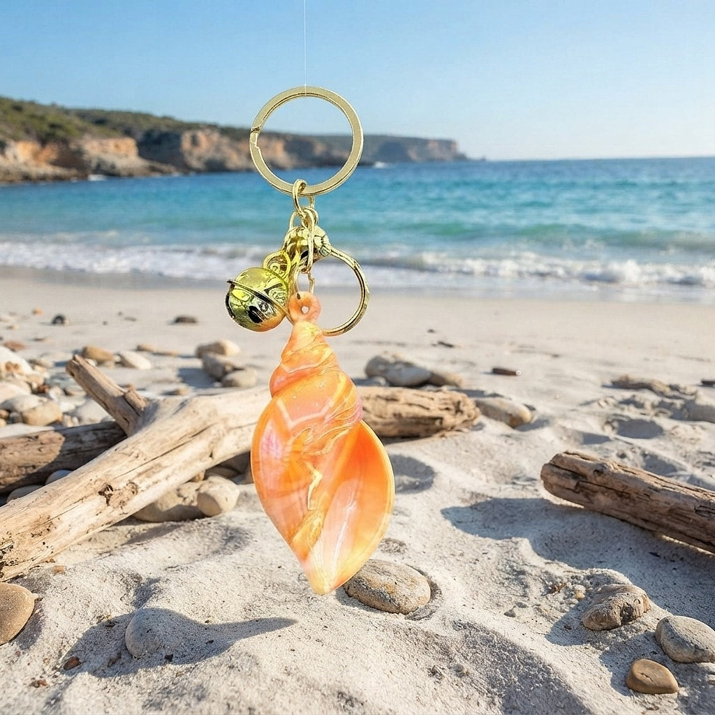 Orange marbled conch keychain in the sand at the beach