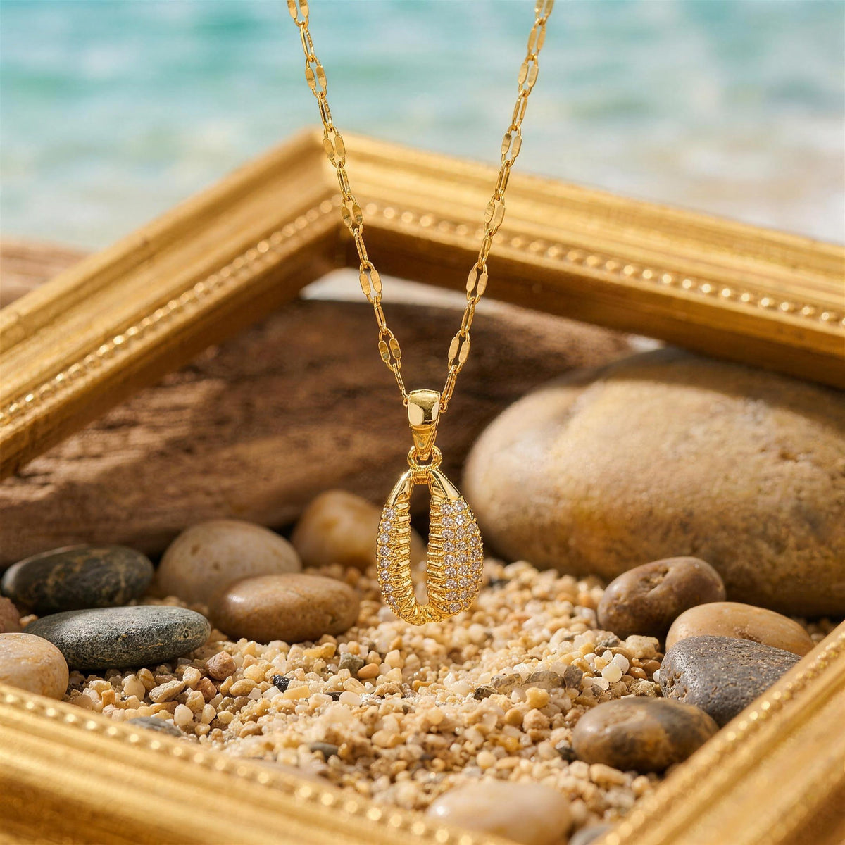 Gold seashell zircon pendant necklace on a gold frame with pebbles