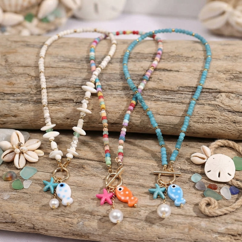Three small ceramic fish and pearl necklaces together